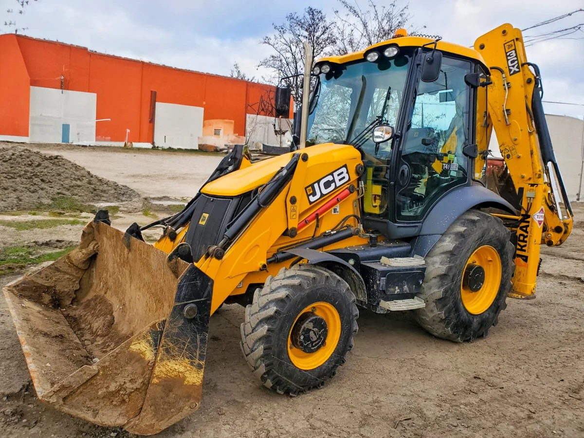 JCB backhoe loader with front bucket on a construction yard