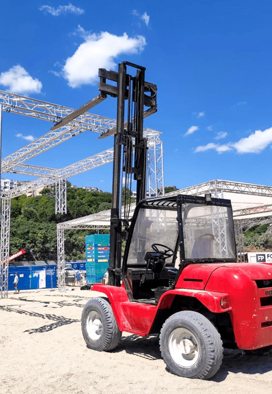 Stivuitor care manipuleaza o structura metalica la un eveniment