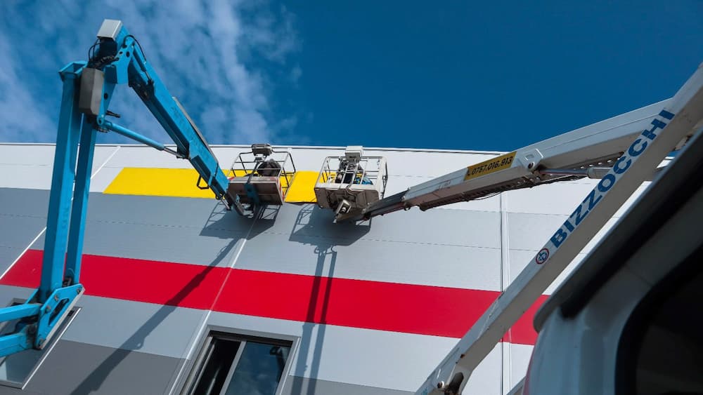 Two aerial work platforms at the facade of an industrial hall