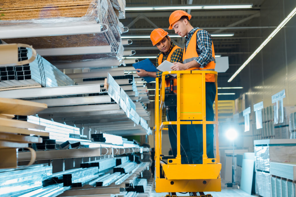 workers using scissor lift in a warehouse