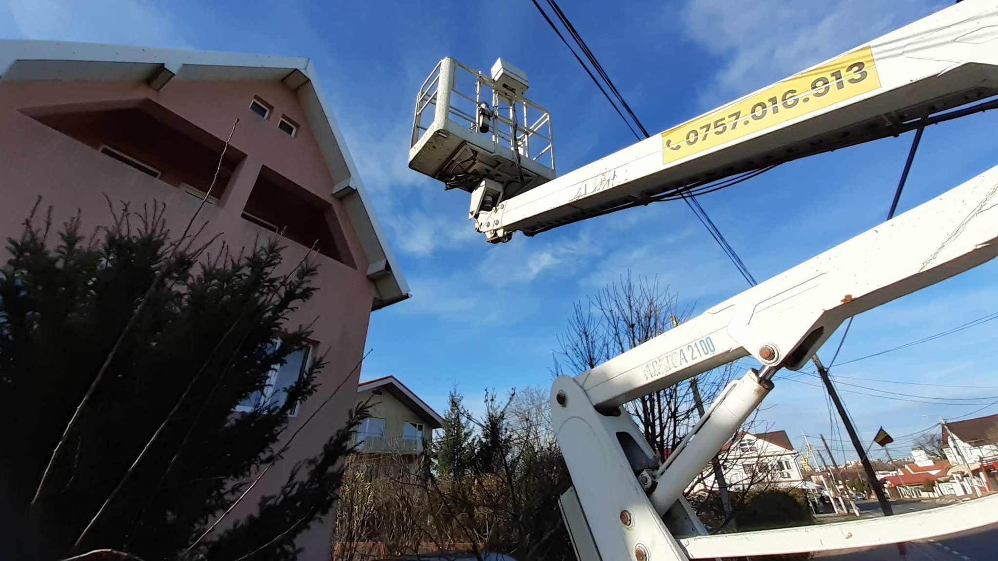 white truck-mounted boom lift preparing to install antenna