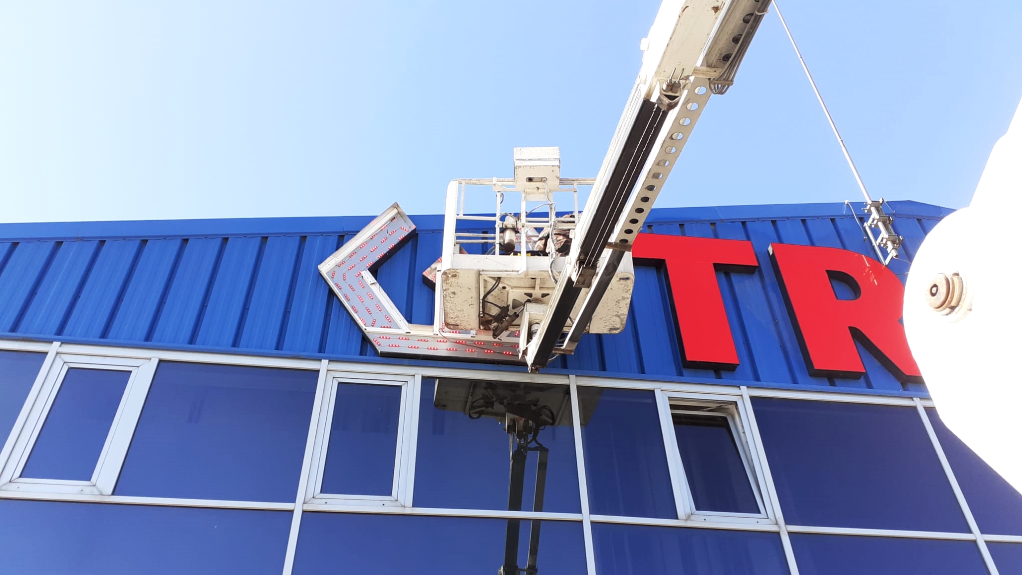 changing the LED lights of the store’s brand signage with truck-mounted boom lift