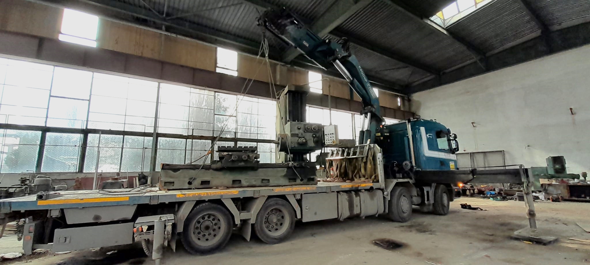 loading heavy piece of equipment using a mobile crane truck