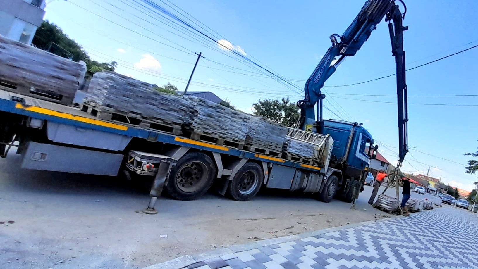 Transportul paleților de pavaje cu un camion cu macara